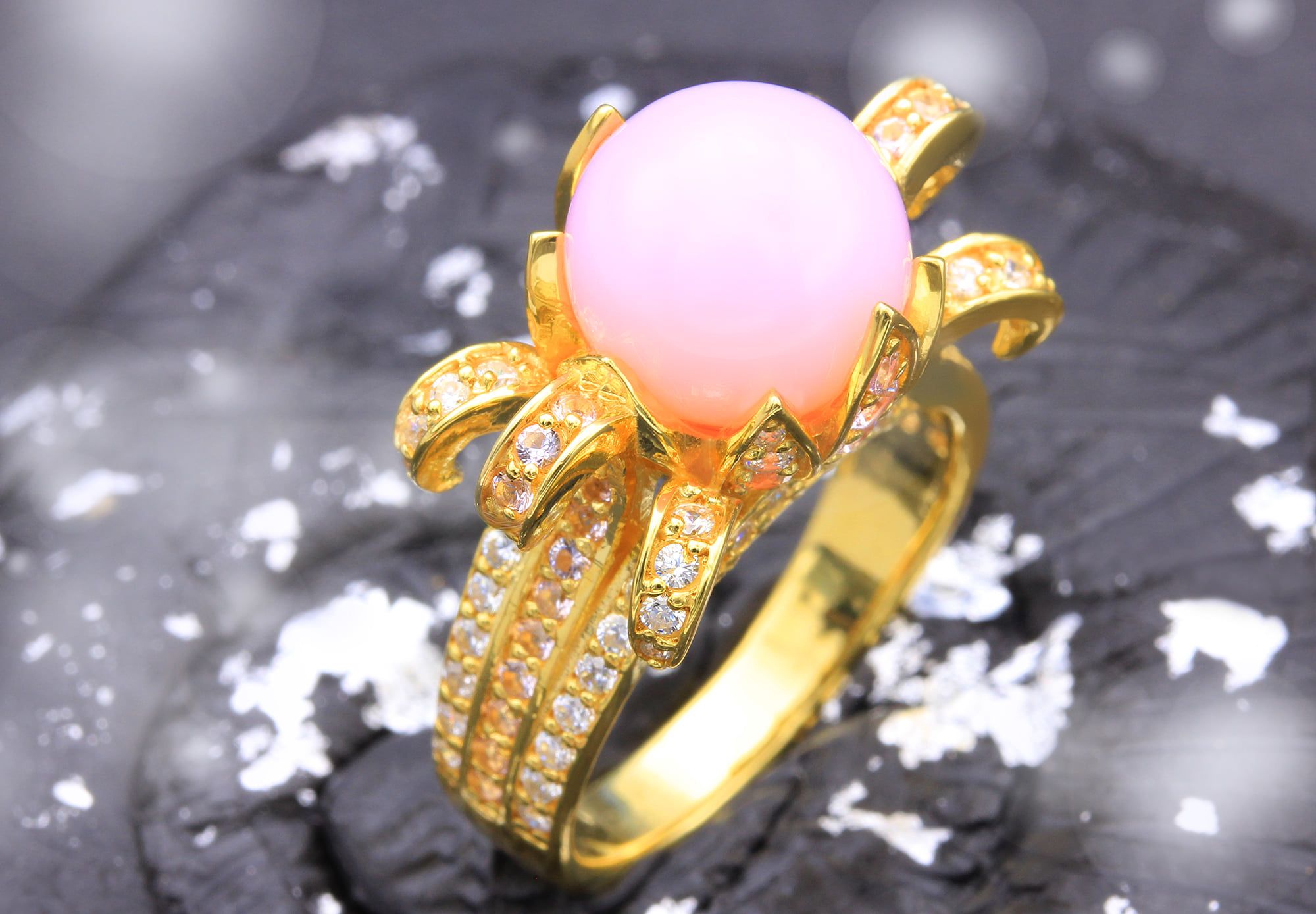 The eye-catching gold plated silver blossom ring with pink opal gemstone reflection and cubic zirconia is always in fashion.